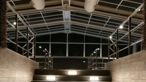 A staircase with illuminated steps and metal railings, leading to an upper level. - Quetzal (Riyadh)