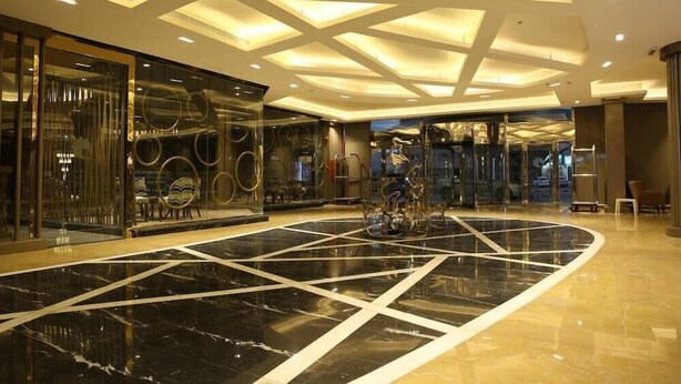 A spacious lobby with a black and white marble floor, modern ceiling design, and glass walls. - Quetzal (Riyadh)