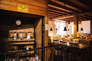 Un intérieur rustique en bois, avec des bancs et des tables en bois, un panneau indiquant une limite de poids et une décoration d’ambiance rustique.