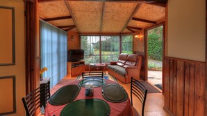 A cozy room with a dining table, chairs, a sofa, and a television. - Stanley Lakeside Spa Cabins (Stanley)