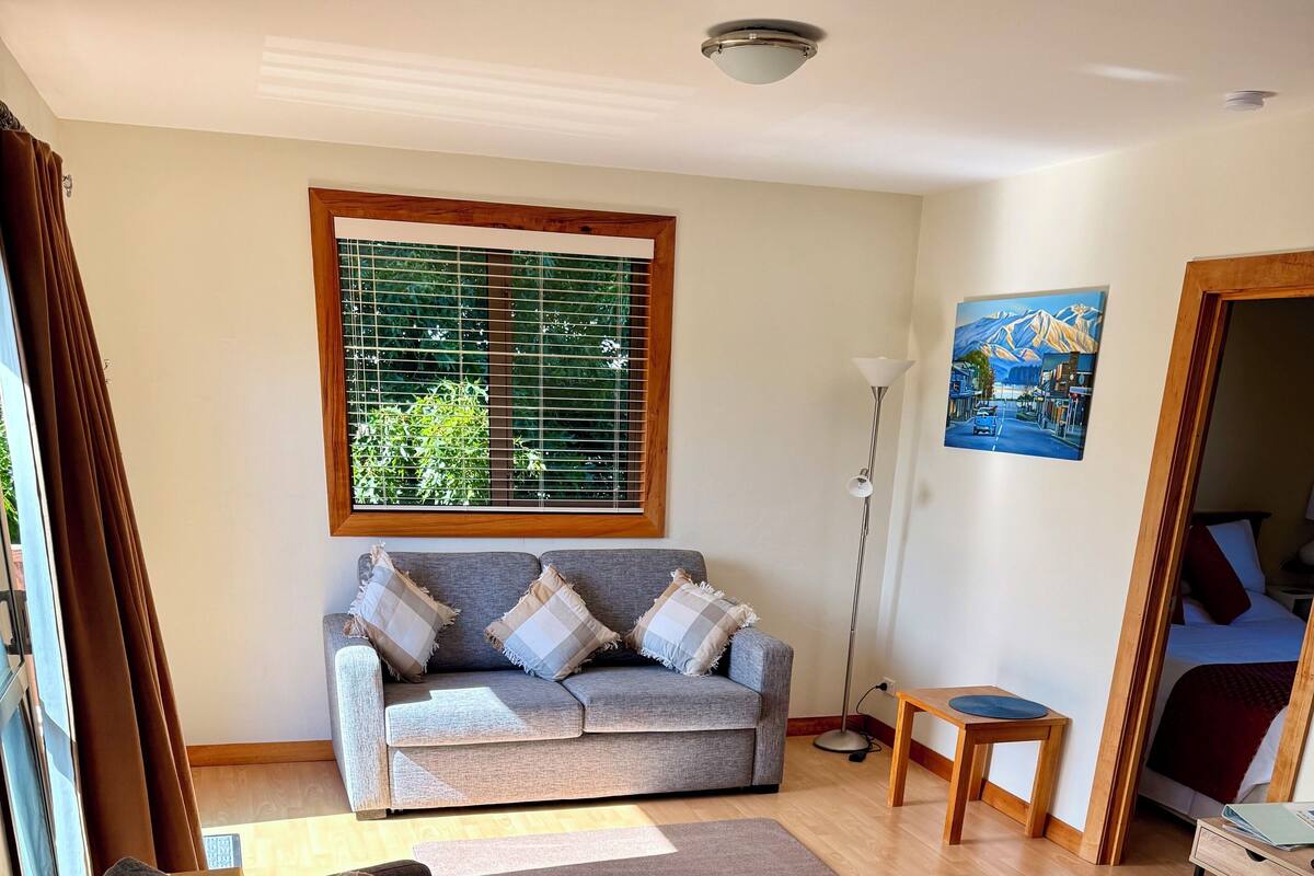 A living room with a grey sofa, a wooden coffee table, and a small side table.