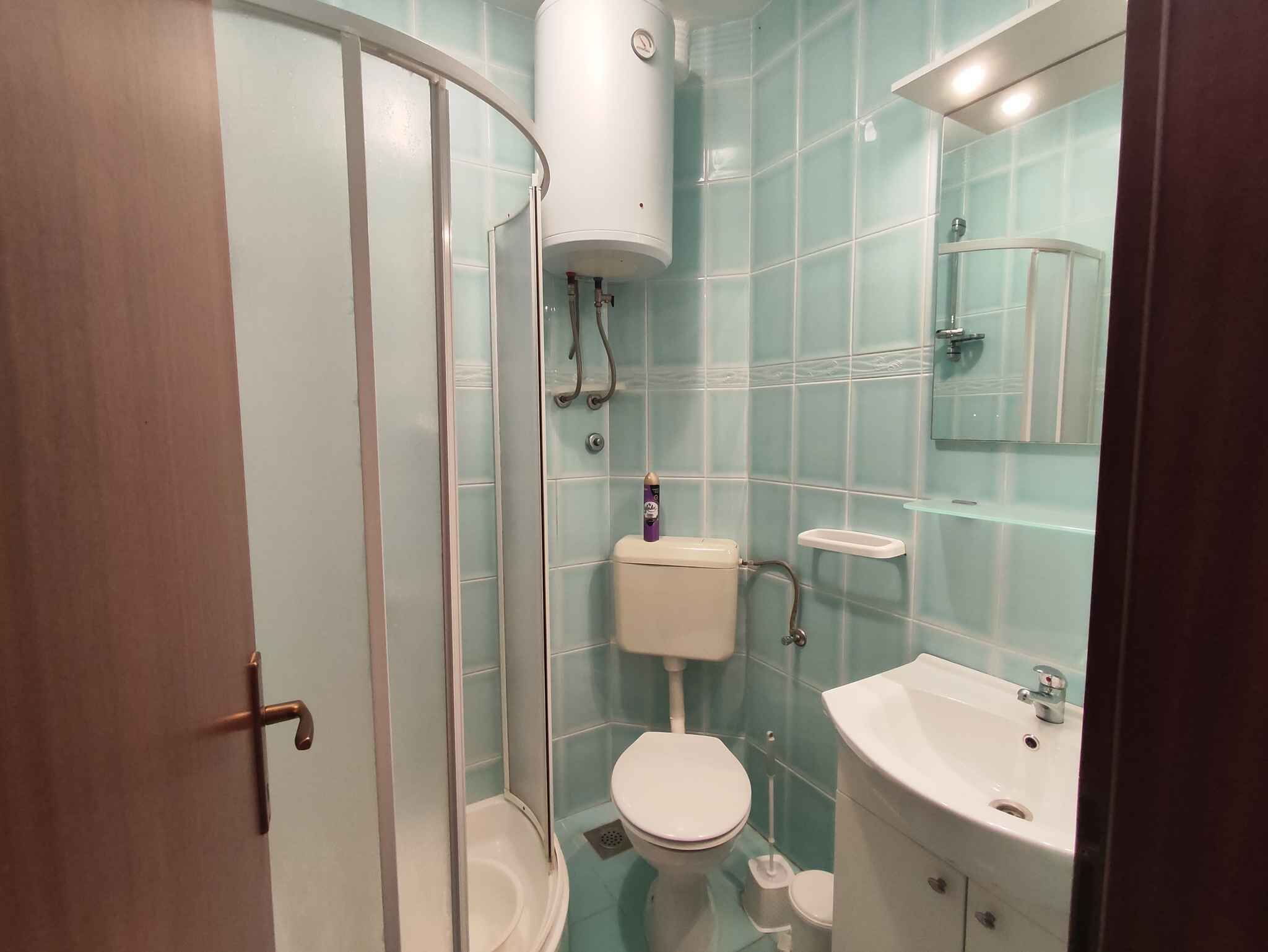 Une salle de bain avec une douche à parois de verre, des toilettes et un lavabo.