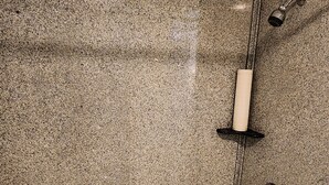 Un baño con una bañera blanca, paredes de granito y zona de ducha.