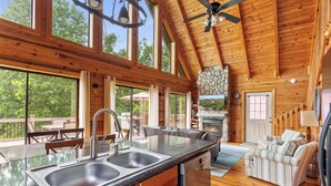 Una cocina amplia con una isla grande, un comedor con asientos exteriores y una chimenea.