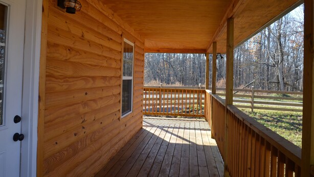 A wooden cabin with a porch, a door, and a window. - Peaceful Farm Atmosphere (Gainesboro)