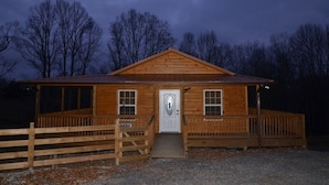 A wooden cabin with a porch, a front door, and a small ramp leading to the entrance. - Peaceful Farm Atmosphere (Gainesboro)