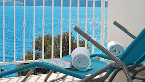 A balcony with a view of the sea, two blue lounge chairs, and a rolled towel on one of the chairs. - EXCLUSIVE LOCATION BEACH APARTMENT "JAN"! NEW OPEN  SWIMMING POOL! (Trogir)