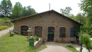 A rustic stone building with a dirt path leading to the entrance, surrounded by greenery. - CANXAI THE RURAL TOURIST HOUSE OF LA GARROTXA PER ENJOY AMB QUI MÉS ESTIMES (La vall de Bianya)