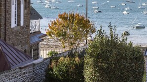 A stone building with a balcony overlooking a harbor filled with sailboats. - Le Timonier - Two Bedroom Apartment, Sleeps 4 (Saint-Malo)
