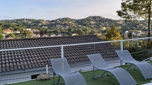 A terrace with metal chairs and a view of a hillside with houses. - Family villa with private pool in Lloret de Mar - 3 bedrooms - quiet (Lloret de Mar)