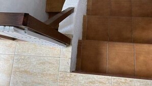A staircase with brown tiles and a wooden handrail. - Family villa with private pool in Lloret de Mar - 3 bedrooms - quiet (Lloret de Mar)