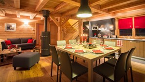 A cozy wooden cabin interior with a dining area, a sofa, and a kitchen. - Wonderful chalet, 50 m from the slopes (Les Deux-Alpes)