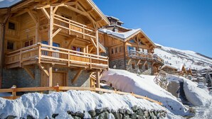 A wooden chalet with balconies and stone walls, surrounded by snow. - Wonderful chalet, 50 m from the slopes (Les Deux-Alpes)