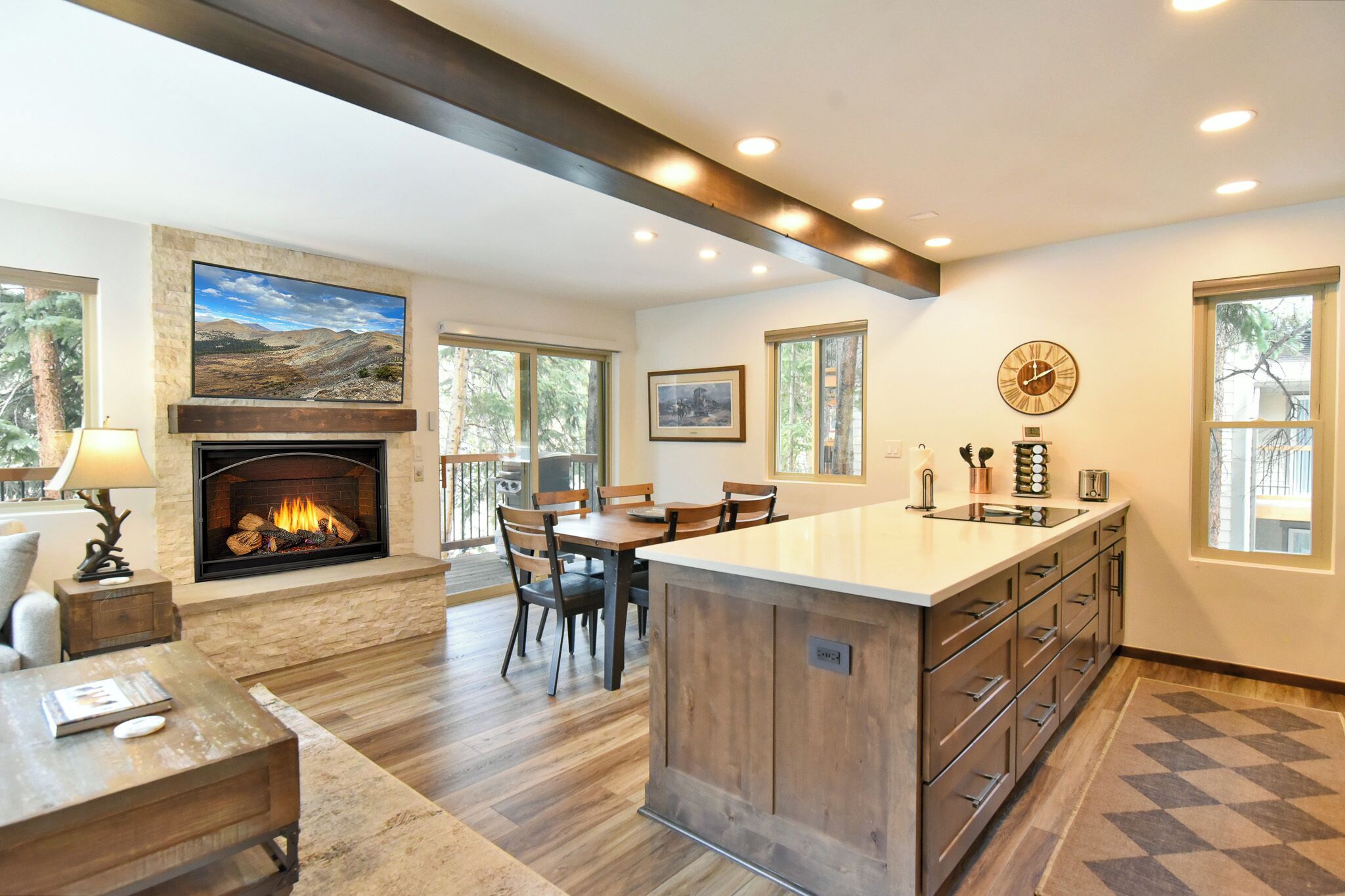A spacious kitchen with a central island, a fireplace, and a dining area.