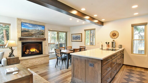 Una cocina amplia con una isla central, una chimenea y un comedor.