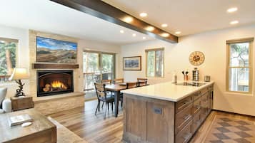 Una cocina amplia con una isla central, una chimenea y un comedor.