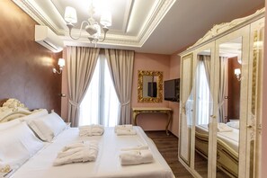 A hotel room with a large bed, a desk, a television, and a mirror.