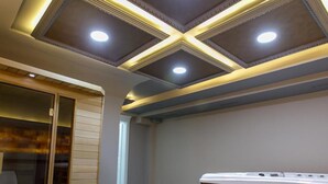 A spa room with a wooden massage table, a hot tub, and a tiled floor.