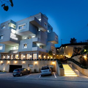 A multi-story hotel with a modern design, featuring balconies and a well-lit entrance. - Elite Palace (Tirane)