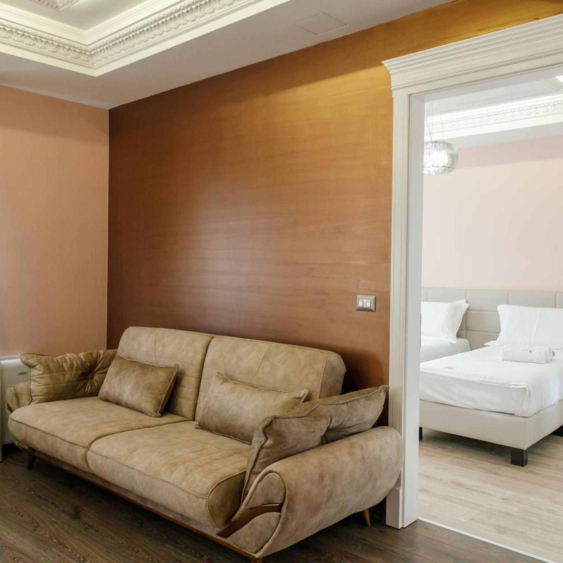Una habitación con sofá, cama y una pared de madera decorativa.
