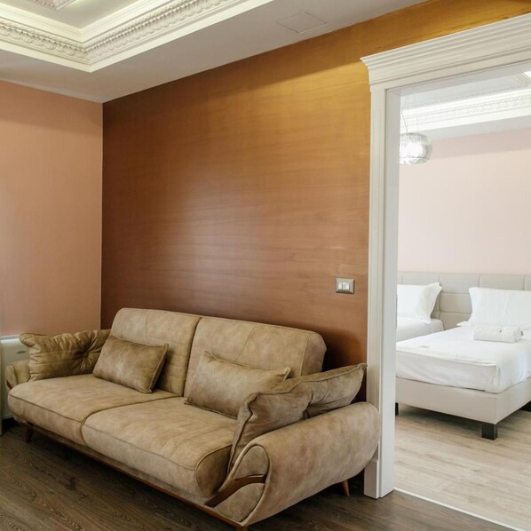 A room with a sofa, a bed, and a wooden accent wall.