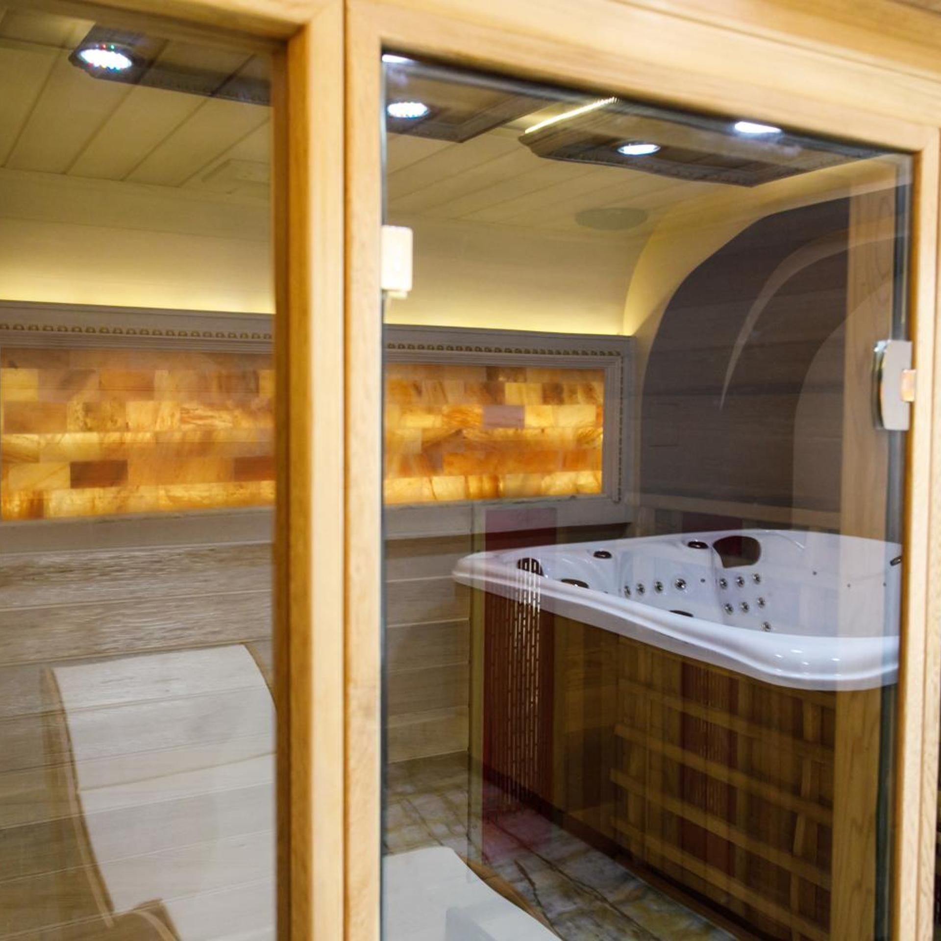 A spa room with a hot tub, wooden paneling, and a tiled floor.