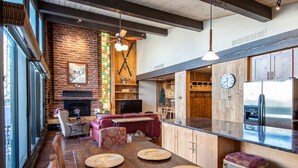 Una cocina moderna con una isla de madera, electrodomésticos integrados y un amplio ventanal con vistas al comedor.