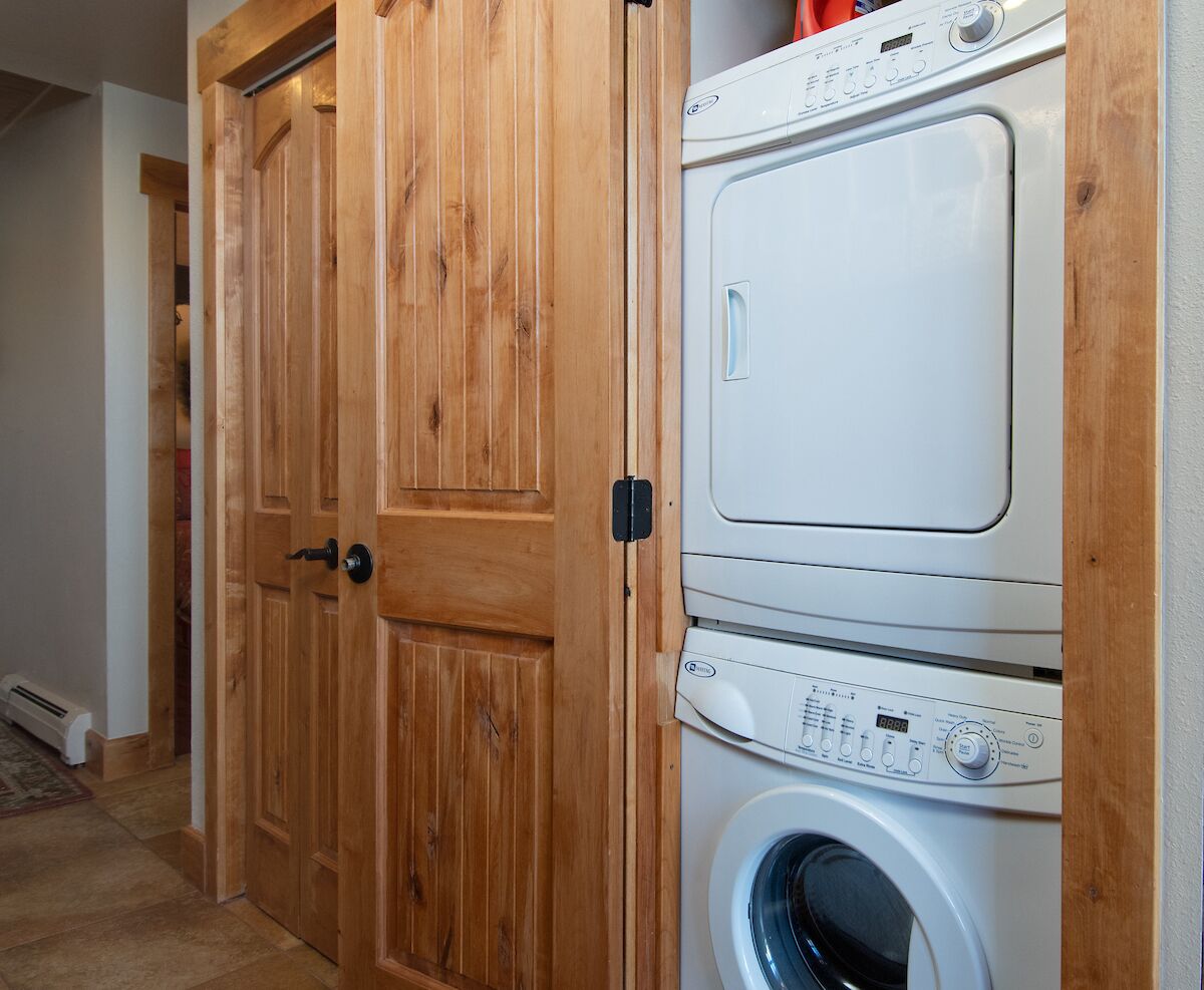 Een wasserette met een houten deur en gestapelde wasmachines.