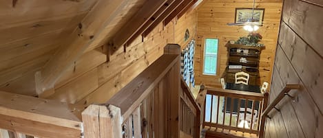 A wooden interior with a staircase leading to a lower level.