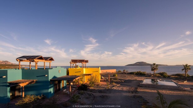 Un complexe hôtelier doté d’une piscine, d’une plage et offrant une vue sur la mer.