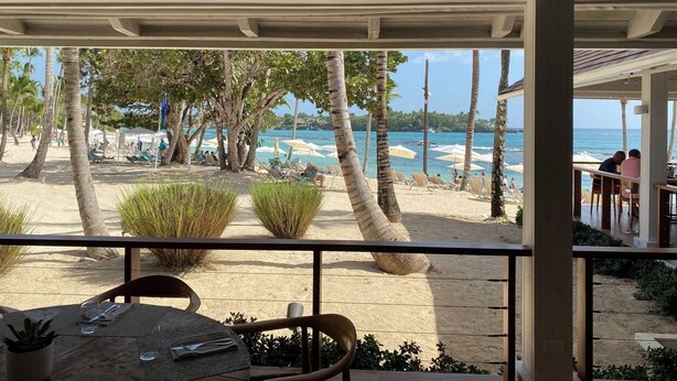 Un restaurante frente a la playa con terraza al aire libre y vistas a la playa y al océano.