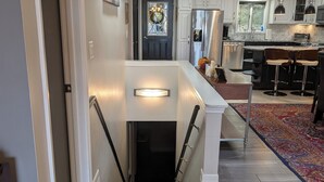 A modern kitchen with a central island, stainless steel appliances, and a patterned rug. - Amazing Lake House With All Amenities (Remsen)