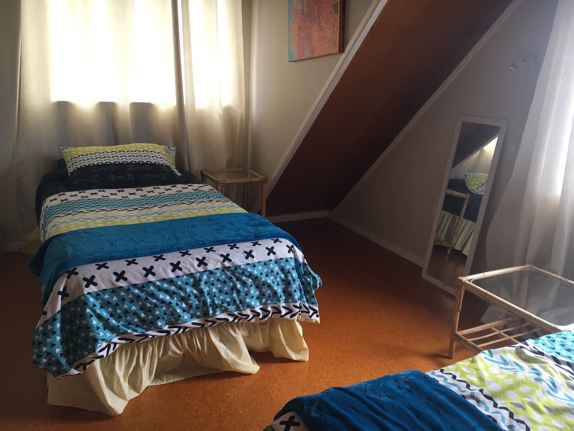 Un dormitorio con una cama, una mesita y un espejo.