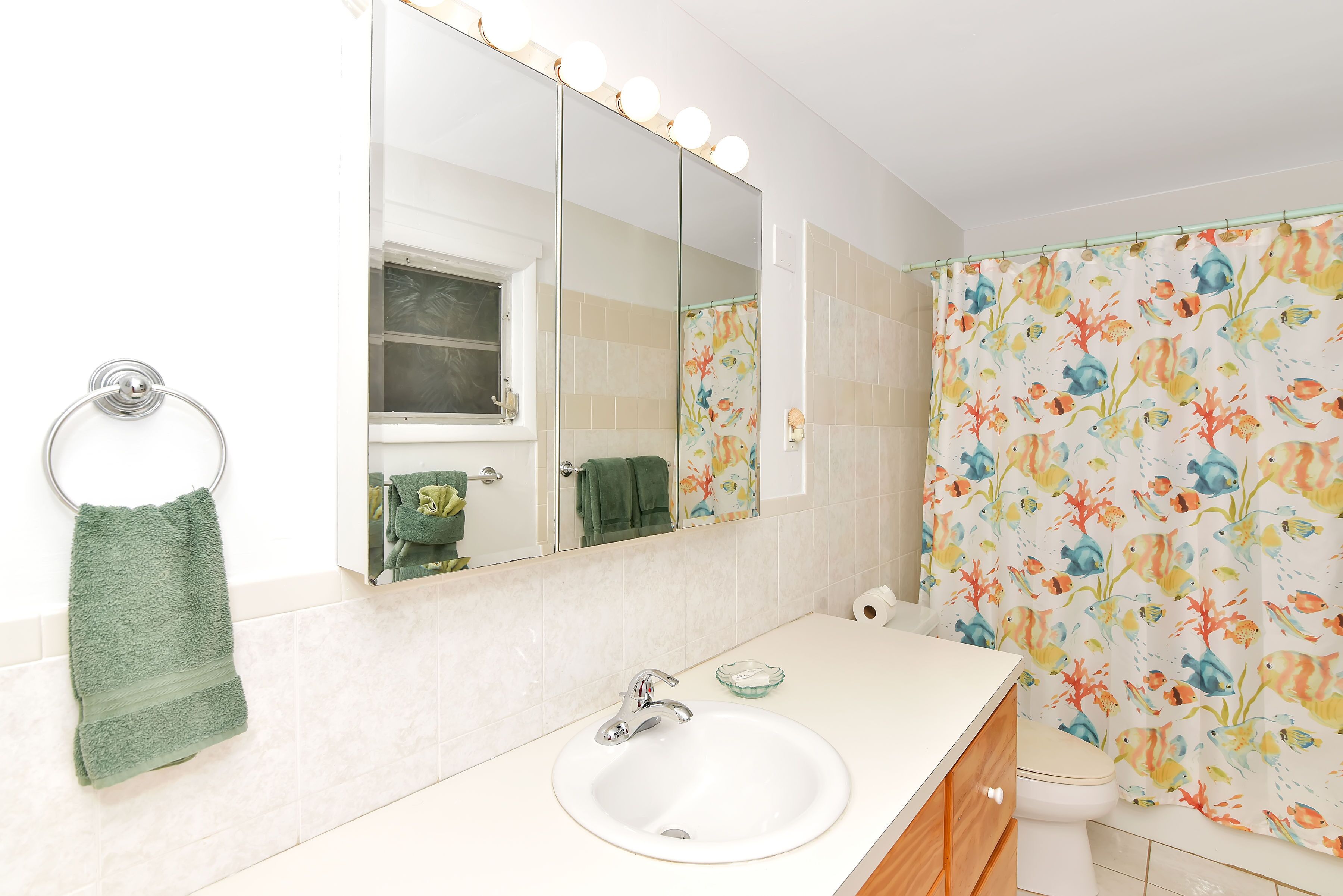A bathroom with a sink, mirror, and shower curtain.