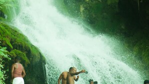 Une cascade avec des personnes debout à proximité.