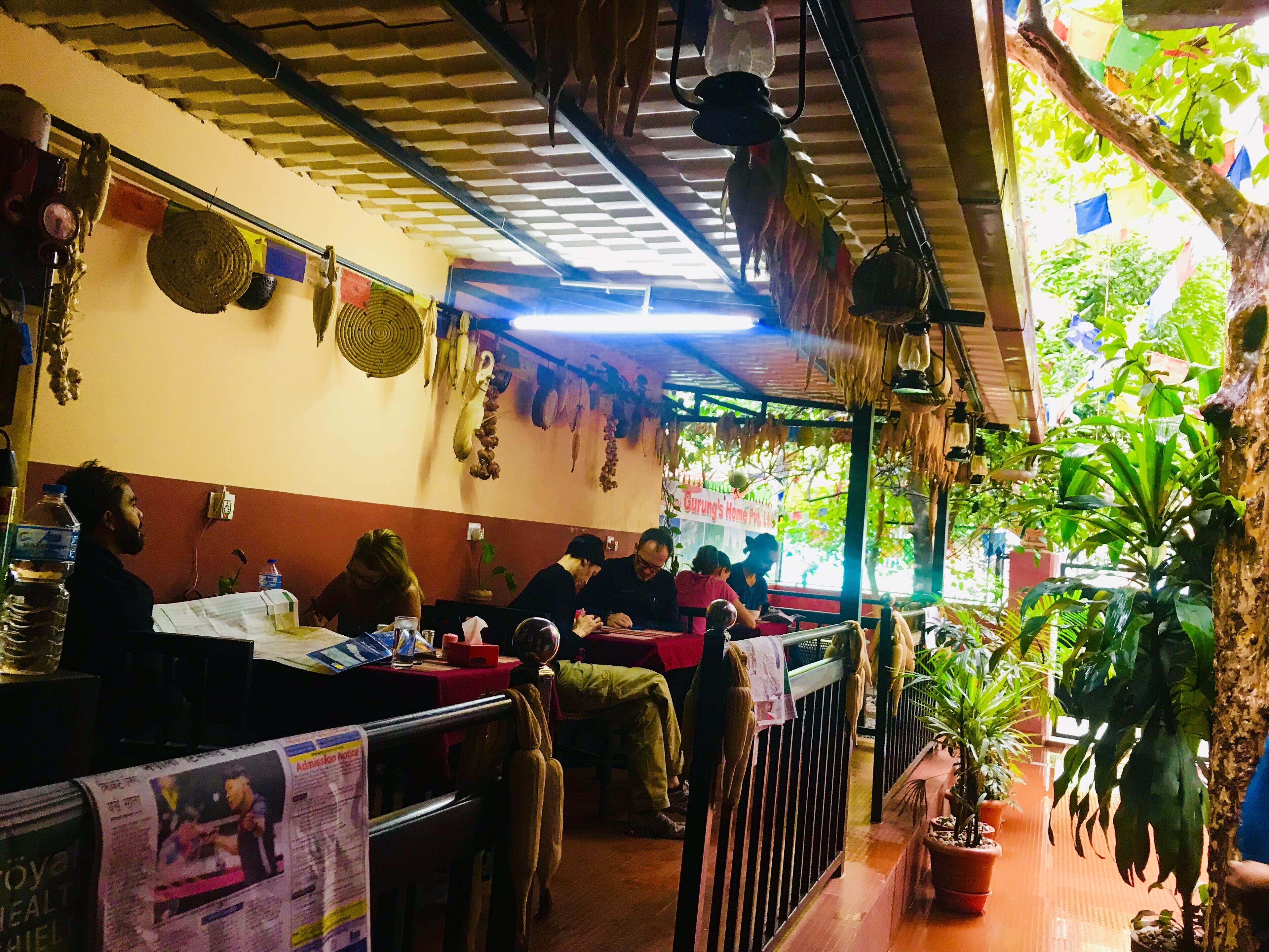 A restaurant with tables and chairs, a counter, and hanging decorations.