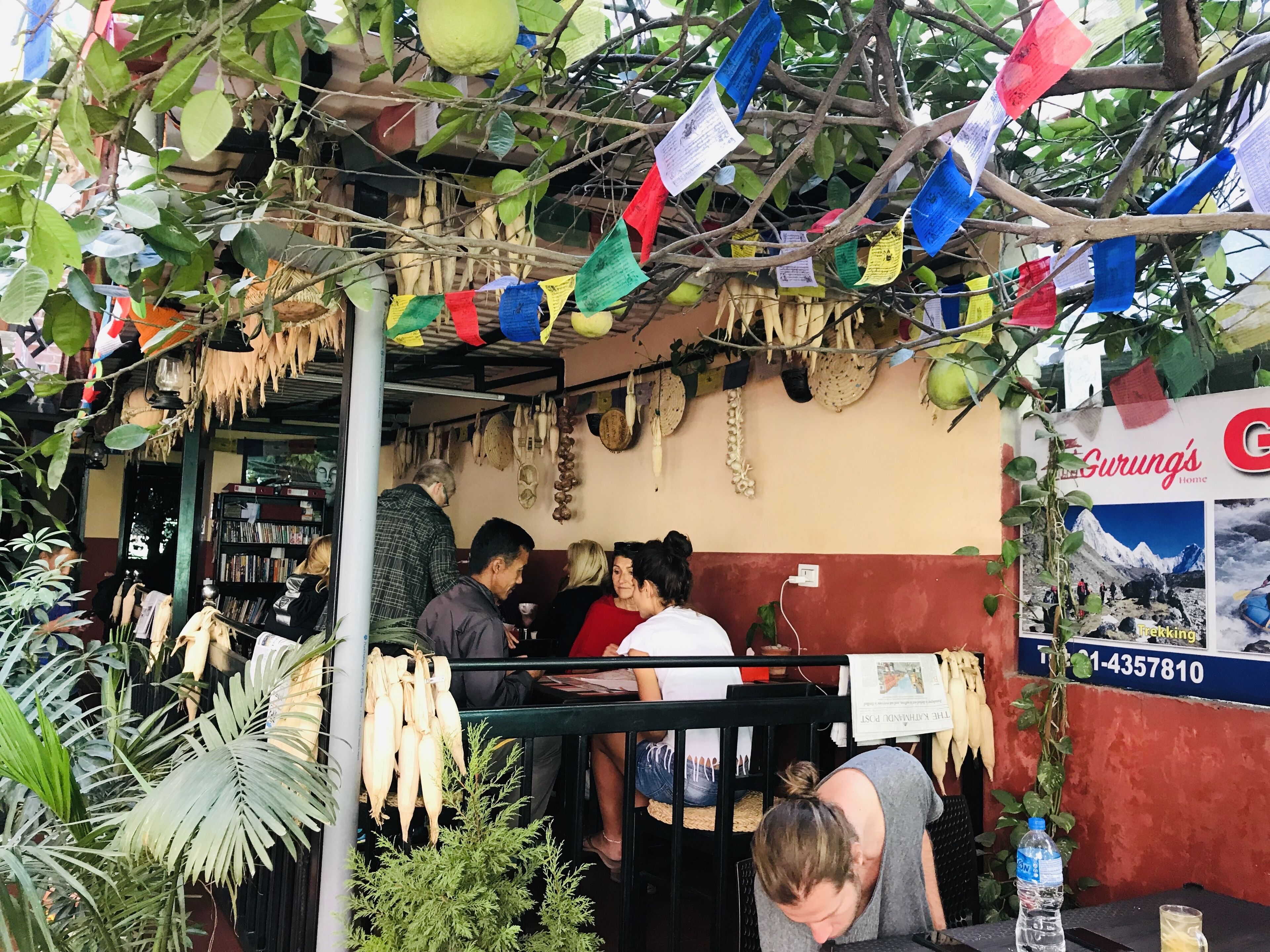 Un restaurante con un interior rústico, que presenta un mostrador, adornos colgantes y una pizarra de menú.