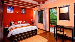 A bedroom with a bed, a desk, and a window with curtains. - Gurung's Home (Kathmandu)