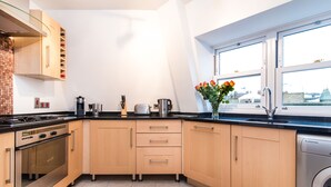 A modern kitchen with wooden cabinets, a built-in oven, and a dishwasher. - River View, Penthouse Apartment, Zone 2, Hammersmith, London, 2 Bedrooms  2 Bath (London)