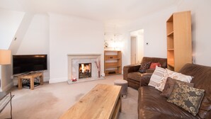A living room with a fireplace, a television, a sofa, and a coffee table. - River View, Penthouse Apartment, Zone 2, Hammersmith, London, 2 Bedrooms  2 Bath (London)