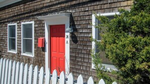 A house with a red door, white picket fence, and a mailbox. - Steps to Commercial St Walk to Beach! (Provincetown)