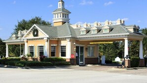 A hotel with a central tower, a covered outdoor area, and a stop sign. - Modern and Spacious 3-Suite Apartment (Kissimmee)