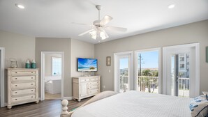 A bedroom with a bed, dresser, TV, and balcony doors. - Crystal Vista with Private Pool, Gulf Views, and Beach Chair Setup (Destin)