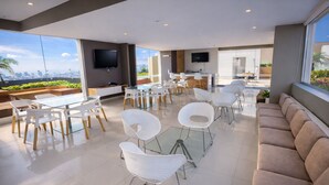 A modern interior with glass tables and chairs, a sofa, and a TV mounted on the wall. - Miraflores Nest - Upper Pardo (Miraflores)