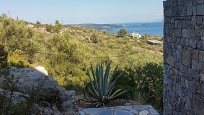 A stone pathway leading to a view of a coastal landscape with a clear sky. - Architect designed Cretan Sea Vista (Chania)