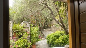 A stone staircase leading to a garden with potted plants and a white wall. - Architect designed Cretan Sea Vista (Chania)