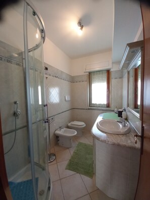 Regadera, secadora de cabello, bidet, toallas