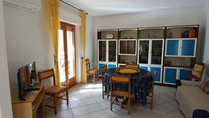 A living room with a dining area, a TV, and a sofa. - House in Teulada for 4 people a few minutes from the beautiful beaches  (Teulada)