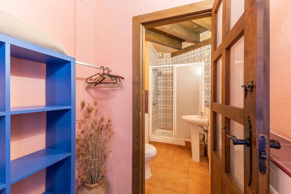 Un baño con ducha, inodoro y lavabo.