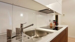 Una cocina moderna con electrodomésticos de acero inoxidable, un lavamanos doble y armarios de madera.